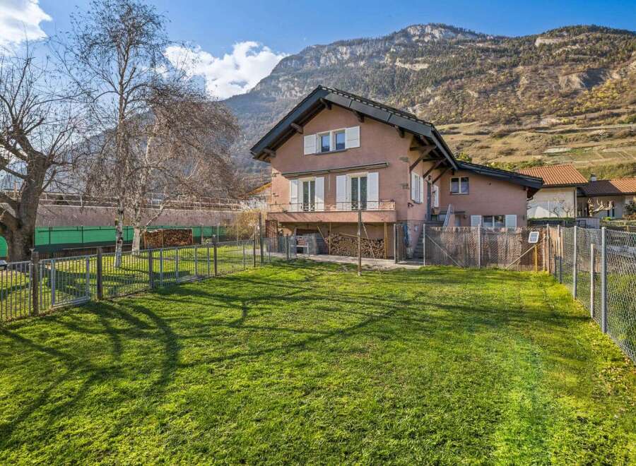 Nestled against a majestic mountain backdrop, this charming property offers a serene retreat with a spacious, sun-drenched lawn perfect for outdoor enjoyment.