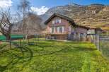 Nestled against a majestic mountain backdrop, this charming property offers a serene retreat with a spacious, sun-drenched lawn perfect for outdoor enjoyment.