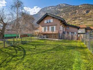 Nestled against a majestic mountain backdrop, this charming property offers a serene retreat with a spacious, sun-drenched lawn perfect for outdoor enjoyment.