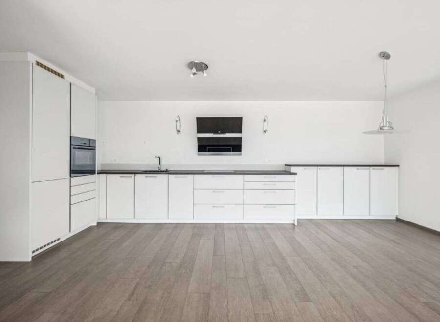 This modern kitchen boasts sleek white cabinetry, offering ample storage and a clean aesthetic.
