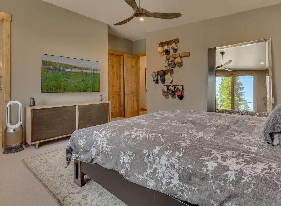 Step into this inviting bedroom, featuring a stylish TV mounted above a sleek cabinet.