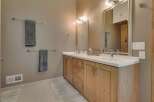 This stunning bathroom features a modern design with a natural wood vanity and a sleek white countertop.