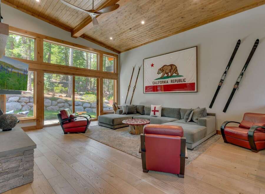 Experience luxury living in this stunning property featuring a spacious living room with expansive windows that offer breathtaking views of the surrounding nature.
