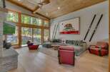 Experience luxury living in this stunning property featuring a spacious living room with expansive windows that offer breathtaking views of the surrounding nature.