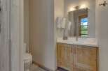 This stunning bathroom features a modern design with natural wood cabinetry and a sleek white countertop.