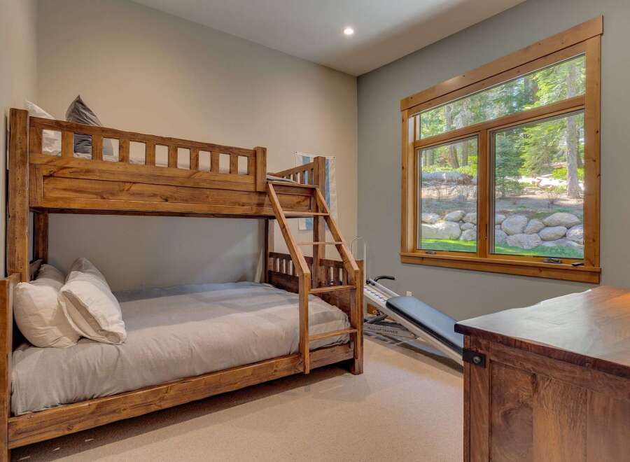 This charming bedroom features a rustic wooden bunk bed, perfect for accommodating guests or family members.