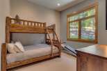This charming bedroom features a rustic wooden bunk bed, perfect for accommodating guests or family members.