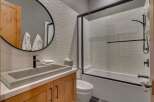 This modern bathroom features a sleek design with a concrete sink and wooden cabinetry.