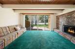 Step into this inviting living space, featuring a cozy fireplace and a vibrant green carpet.
