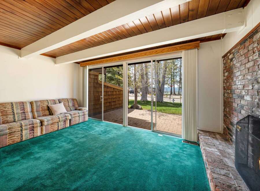 Step into this inviting living space, featuring a cozy sofa and a vibrant green carpet that adds a touch of freshness.