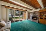 Step into this inviting living space, featuring a cozy brick fireplace and a vibrant green carpet that adds a touch of warmth.