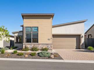 This stunning modern home boasts a beautiful exterior with a combination of stone and siding.
