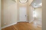 Step into this stunning entryway, showcasing beautiful hardwood floors and a modern, geometric light fixture.