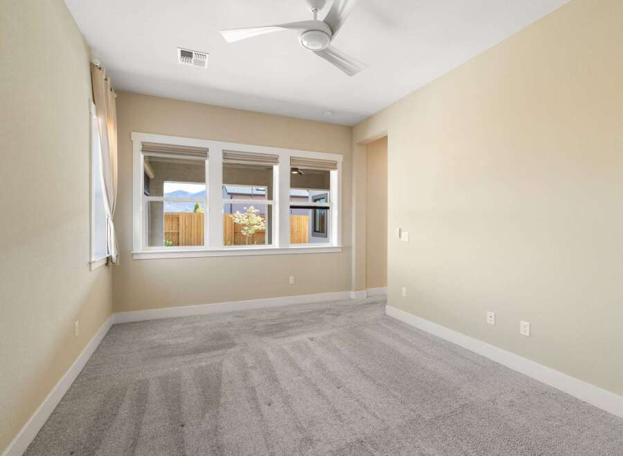 Step into this bright and airy bedroom, featuring a neutral color palette and plush carpeting.