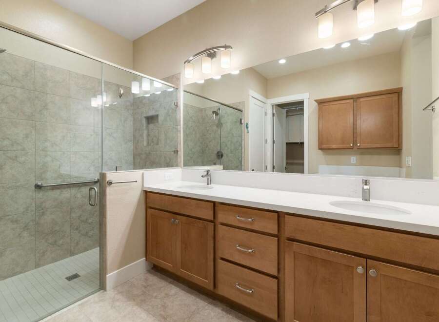 Step into luxury with this stunning bathroom, featuring a spacious glass-enclosed shower and elegant vanity.