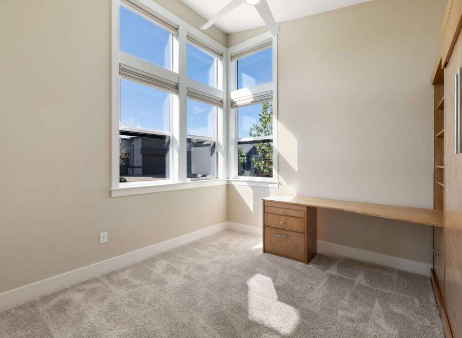 This bright and airy room features a large corner window that floods the space with natural light.