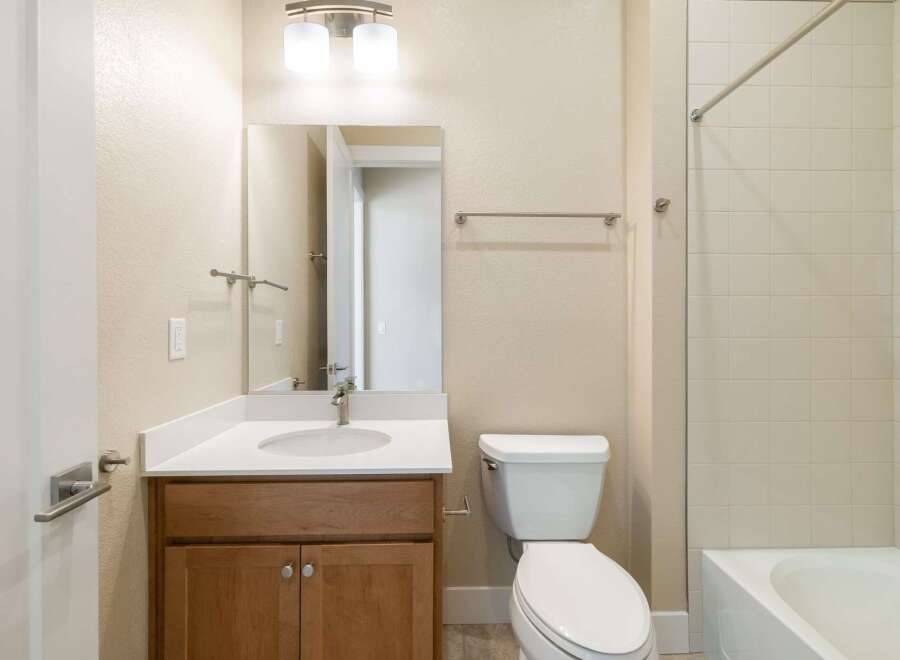 This beautiful bathroom features a modern vanity with a sleek countertop and a stylish faucet.