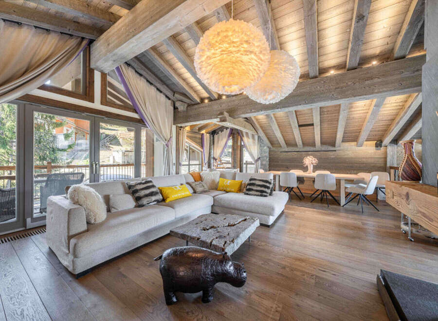 Experience luxury living in this stunning property, featuring a spacious living area with a cozy fireplace and a modern dining space.