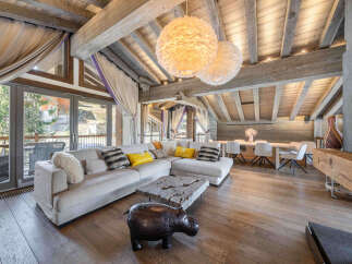 Experience luxury living in this stunning property, featuring a spacious living area with a cozy fireplace and a modern dining space.
