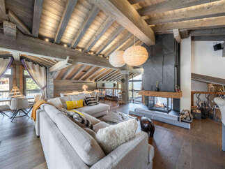 Experience luxury living in this stunning chalet, featuring a cozy living room with a fireplace and a spacious layout.
