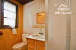 Discover this charming bathroom featuring a cozy wooden interior and a bright window.