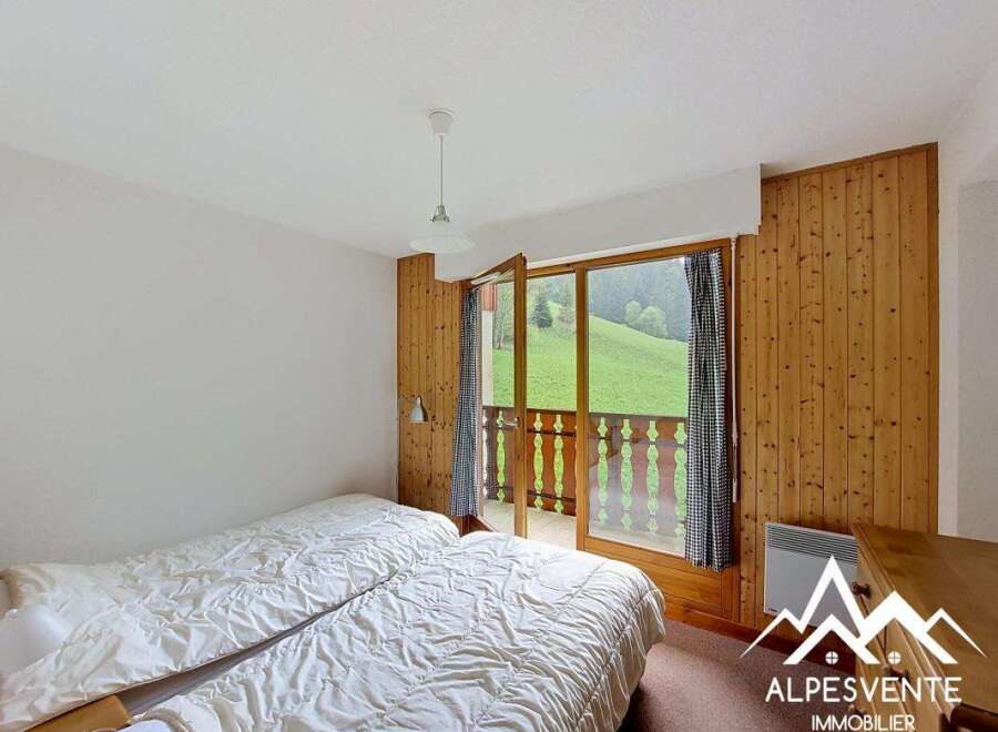 Discover a cozy bedroom with stunning views! This charming space features two comfortable beds, perfect for a relaxing stay.