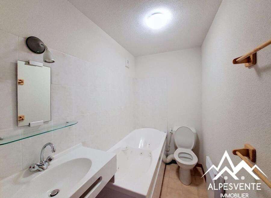 Discover this charming bathroom featuring a sleek white sink and a relaxing bathtub.