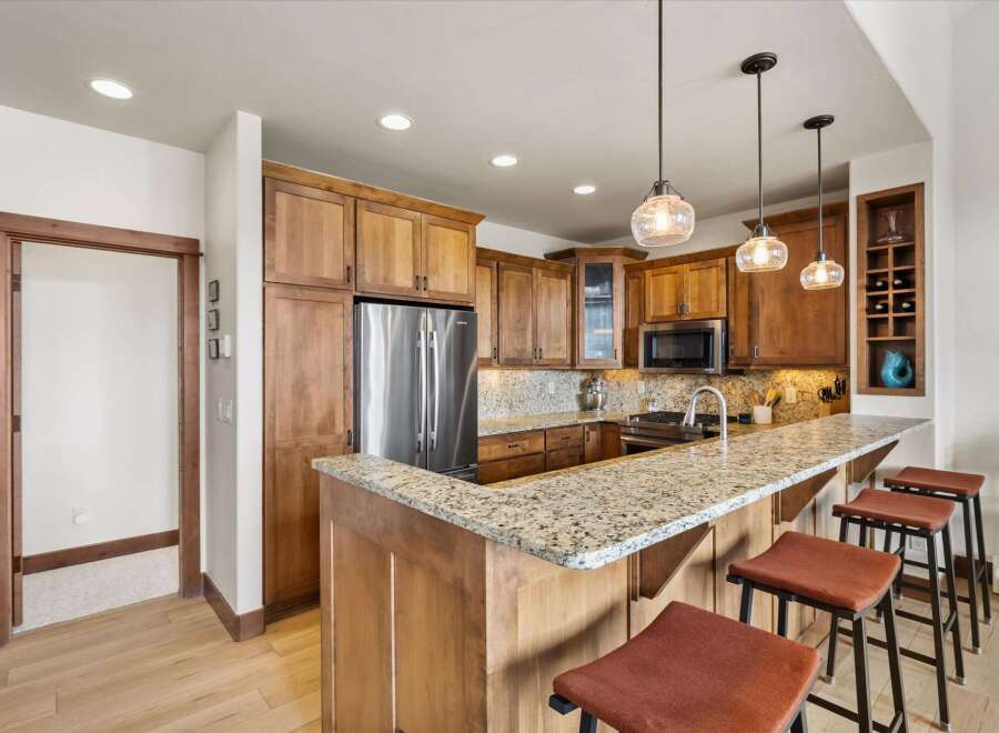 This stunning kitchen boasts beautiful wooden cabinetry and a spacious granite countertop, perfect for meal preparation and entertaining.