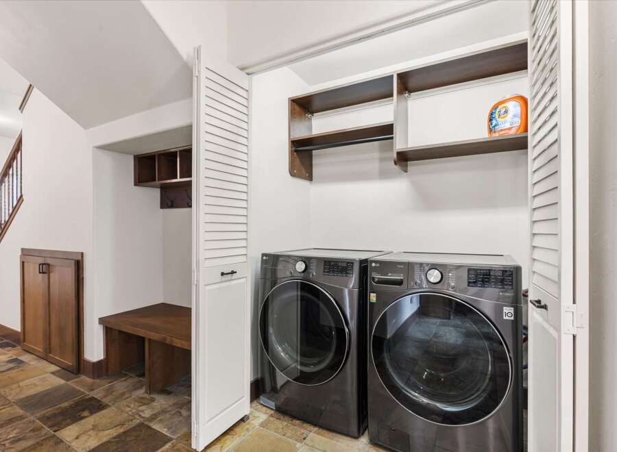 Step into this beautifully designed laundry room, featuring modern appliances and ample storage solutions.