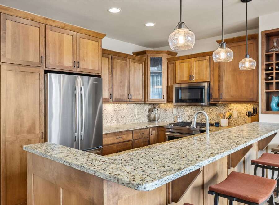 This stunning kitchen boasts beautiful wooden cabinetry and a spacious granite countertop, perfect for meal preparation and entertaining.
