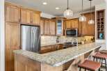 This stunning kitchen boasts beautiful wooden cabinetry and a spacious granite countertop, perfect for meal preparation and entertaining.