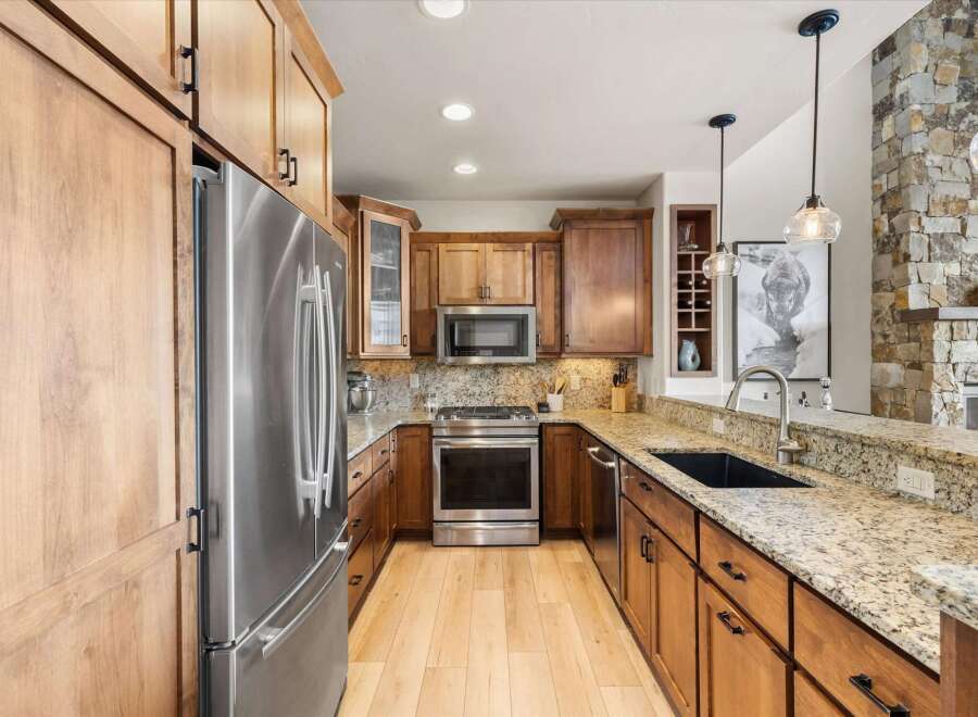 This stunning kitchen boasts custom cabinetry, stainless steel appliances, and granite countertops, creating a luxurious and functional space.