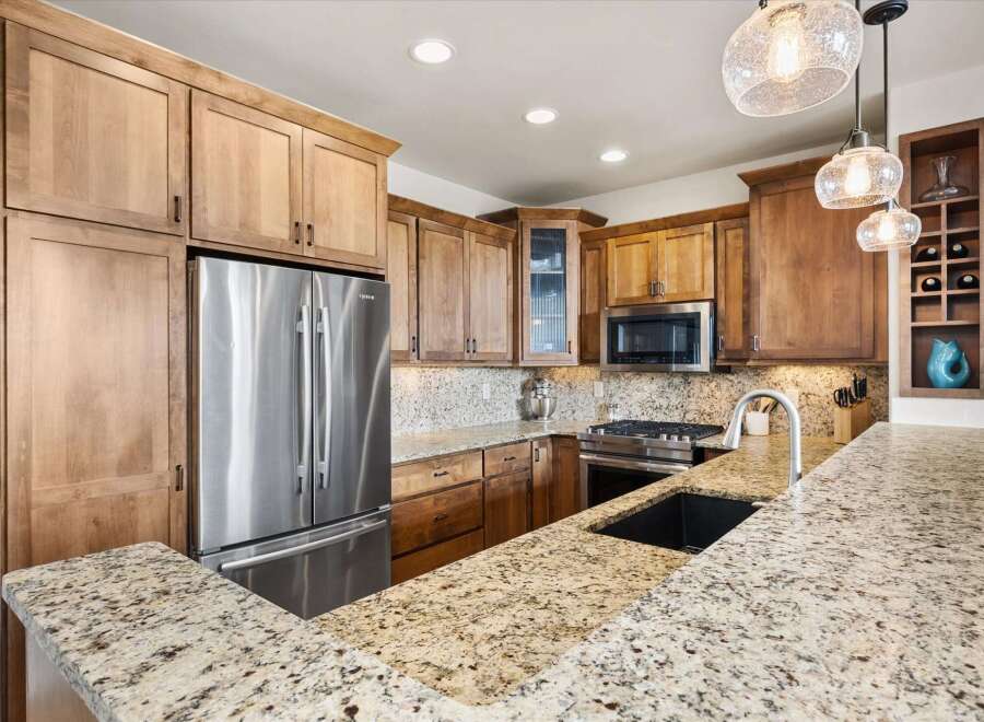 This stunning kitchen boasts beautiful wooden cabinetry and a spacious layout, perfect for both cooking and entertaining.