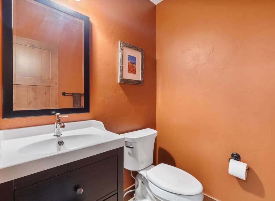 This stunning bathroom features a modern vanity with a sleek white sink and a stylish black-framed mirror.