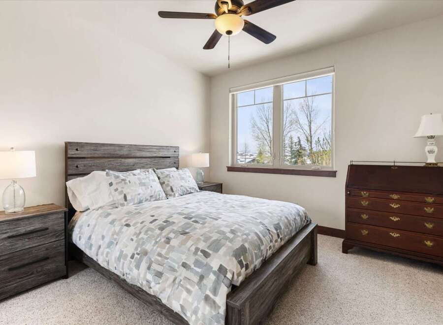 This inviting bedroom features a stylish bed with a patterned comforter and a rustic wooden headboard.