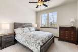 This inviting bedroom features a stylish bed with a patterned comforter and a rustic wooden headboard.