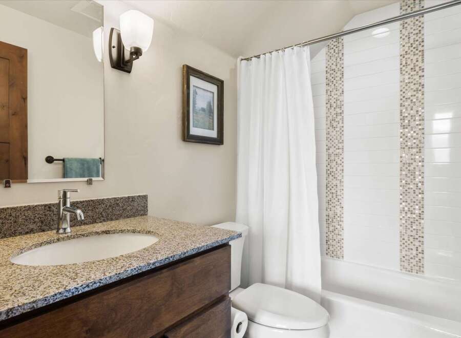 This beautiful bathroom features a modern design with a granite countertop and a stylish sink.