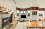 This stunning living room boasts a cozy fireplace with a stone surround, perfect for those chilly evenings.