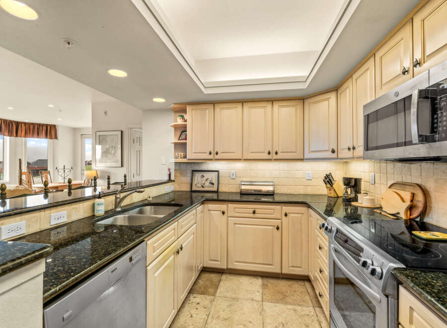 This stunning kitchen boasts elegant granite countertops and ample cabinet space, perfect for culinary enthusiasts.