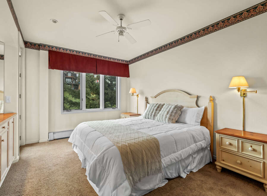 This cozy bedroom features a comfortable bed with plush pillows and a stylish throw blanket.