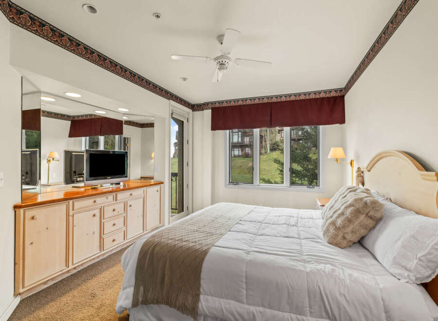This inviting bedroom boasts a cozy ambiance with its plush bedding and elegant headboard.