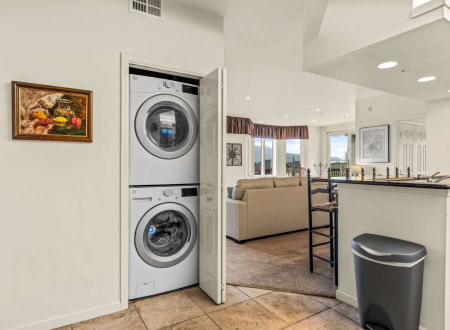 This stunning property boasts a modern laundry area with a stacked washer and dryer, perfect for convenient living.