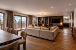 Experience luxury mountain living in this stunning chalet, featuring a spacious open-plan living area with a cozy fireplace and breathtaking panoramic views of snow-capped peaks.