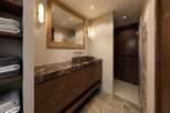 Experience luxury in this modern bathroom featuring a stunning marble vanity with a vessel sink and warm wood cabinetry.