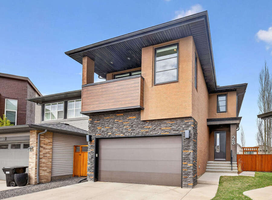 This stunning modern home boasts a striking exterior with a combination of stone and stucco.