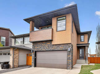 This stunning modern home boasts a striking exterior with a combination of stone and stucco.