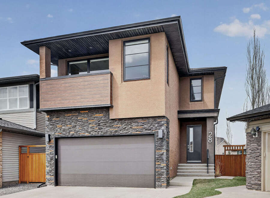 This stunning modern home boasts a striking exterior with a combination of stone, stucco, and wood accents.