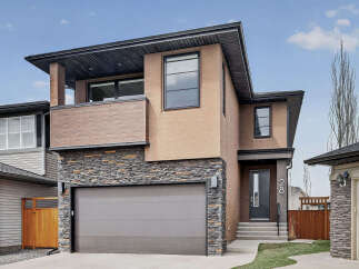 This stunning modern home boasts a striking exterior with a combination of stone, stucco, and wood accents.