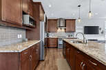 This stunning kitchen boasts rich, dark wood cabinetry and elegant granite countertops, creating a warm and inviting atmosphere.