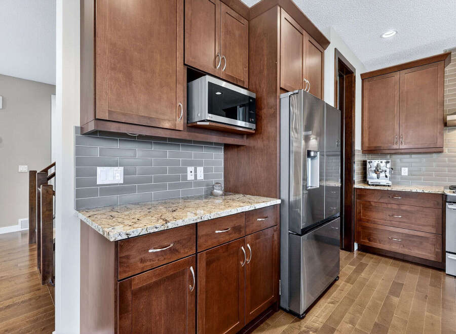 This stunning kitchen boasts rich, dark wood cabinetry and sleek stainless steel appliances, creating a warm and inviting atmosphere.